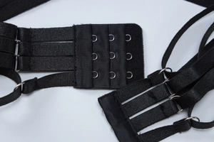 Macro view of black three-row bra extender with elastic fabric and metal hooks
