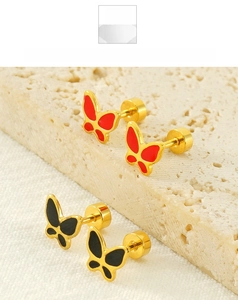 Vue détaillée des boucles d'oreilles papillon en or 18 carats avec émail rouge et noir