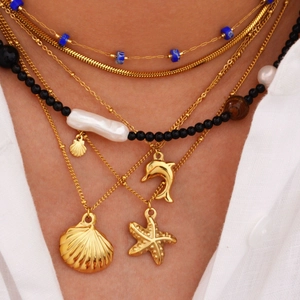 Layered gold starfish and seashell necklace with pearls and beads on model
