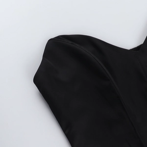 Détail du tissu en satin noir et des coutures fines sur un haut corset ajusté sexy