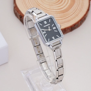 Detail view of silver square watch dial with Roman numerals and chain strap on display