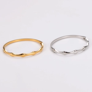Minimalist wave-patterned stainless steel bangles in gold and silver finishes