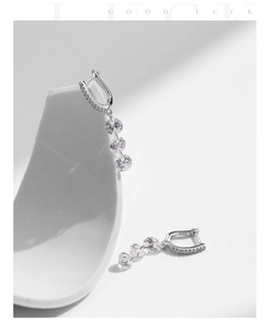 Close-up of S925 sterling silver hoop earrings with three dangling round zirconia stones