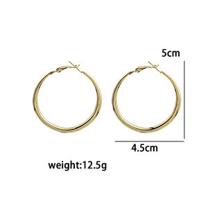 Detail showing two sizes of golden metal hoop earrings with 5cm and 4.5cm diameters