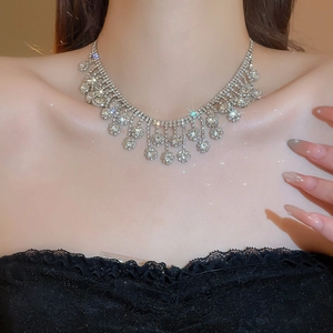 Macro detail of silver necklace with cubic zirconia floral tassels on a model's neck