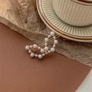Detailed macro view of golden pearl hair clip on a vintage brown leather texture