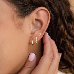 Close-up of three gold S925 sterling silver hoop earrings with sparkling zircon stones