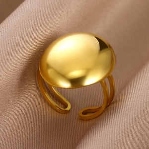Detail of a polished golden dome ring with adjustable double-band design on silk fabric