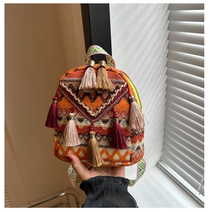 Detail of colorful embroidered backpack with ethnic geometric patterns and stylish tassels