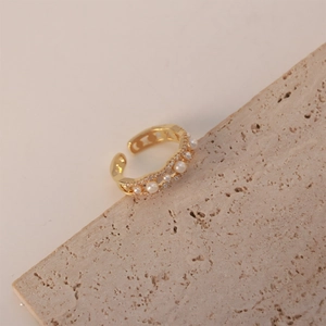 Detail showing artificial pearls and small zircon stones on the wavy gold open ring
