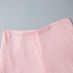 Macro view of pink chiffon fabric with shimmering pleated texture and satin finish