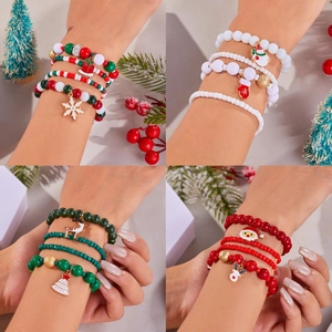 Dettaglio dei braccialetti natalizi con ciondoli a forma di Babbo Natale e renna