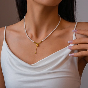 Vue détaillée du collier de perles avec pendentif gourde dorée et pierre en zircone