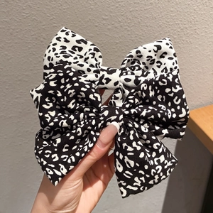 Pair of black and white leopard print fabric bow hair clips for elegant styling