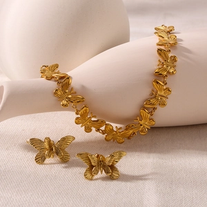 Elegant 18K gold plated butterfly necklace and earrings set on minimalist ceramic base