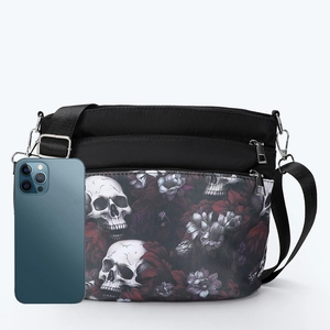 Black gothic skull floral crossbody bag with multiple zippers and phone for size reference