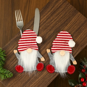 Close-up of gnome silverware holders with red and white striped hats on wooden tray