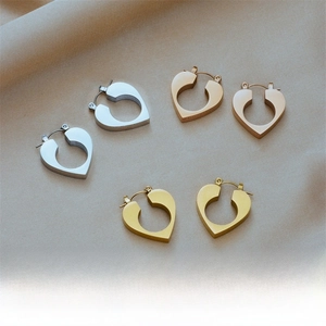 Detailed view of polished heart-shaped earrings in silver, rose gold, and gold finishes