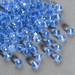 Macro detail of royal blue faceted crystal glass beads scattered on matte background