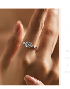 Close-up of a 6-prong brilliant round cut moissanite ring with channel-set side stones