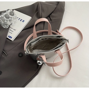 Vue de dessus d'un sac à main argenté et rose montrant l'intérieur et le bijou de sac