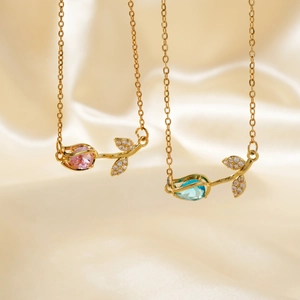 Elegant gold tulip necklaces with pink and blue drop stones on champagne silk background