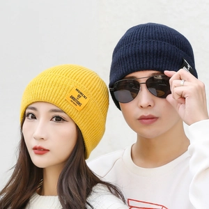 Unisex warm knitted beanie hats in bright yellow and deep blue with embroidered patch