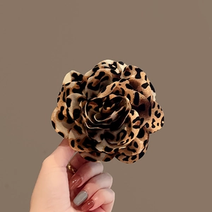 Detail of leopard print fabric flower hair claw clip with multi-layered petal design