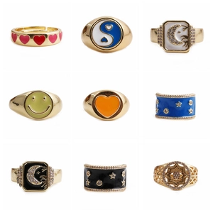 Set of 9 gold adjustable rings with heart, yin-yang, and celestial patterns on white background