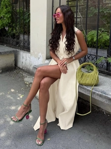 Detail of a beige sleeveless maxi dress with a waist tie and side slits for a summer look