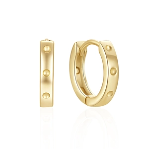 Macro shot of gold-plated hoop earrings with raised dotted pattern on a white background