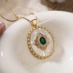 Vintage 18K gold plated necklace featuring an oval shell pendant with emerald gemstone