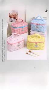 Detailed set of four quilted lattice cosmetic bags with cute bow embroidery and top handles