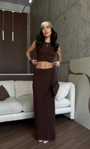 Detail view of dark brown knitted two-piece set featuring sleeveless buttoned crop top and skirt