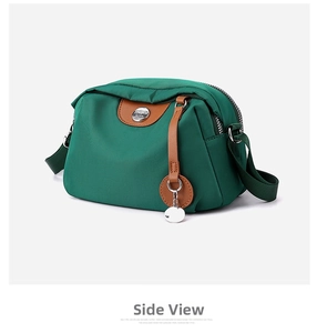Dettaglio borsa a tracolla in nylon verde scuro con finiture in similpelle marrone e logo