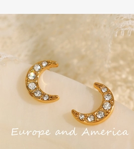 Vue macro de boucles d'oreilles lune plaquées or 18k serties de zircons brillants