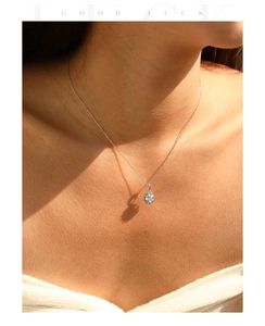 Detail of silver S925 necklace with octagonal halo pendant worn on a model in sunlight