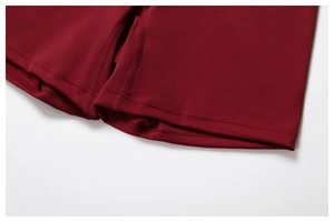 Dettaglio della cucitura piatta professionale a quattro aghi sui pantaloncini da yoga bordeaux