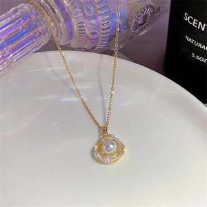 Elegant gold necklace featuring a pearl pendant surrounded by sparkling rhinestones
