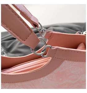 Detailed view of pink floral pattern texture and silver metal hardware on handbag
