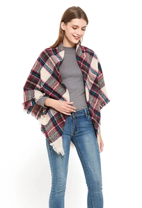 Detailed view of women's oversized plaid shawl with fringes in red and green colors
