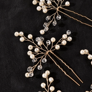 Macro detail of gold bridal hair pin with handcrafted pearls and faceted crystal beads