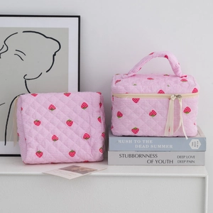 Pink quilted travel makeup bag set with strawberry prints and a top handle strap