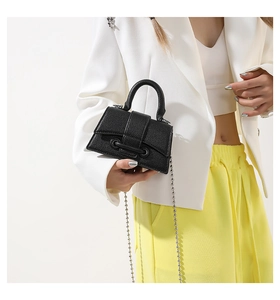 Detail of black pebbled leather mini handbag with silver bead chain and eyelet accents