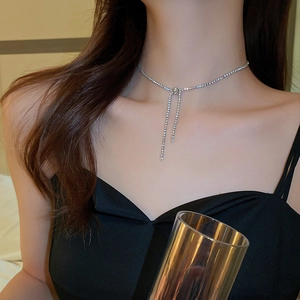 Close-up of silver bow necklace with zircon tassel and adjustable Y-shape chain design