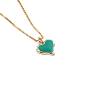 Minimalist gold chain necklace featuring a vibrant green heart enamel pendant on white
