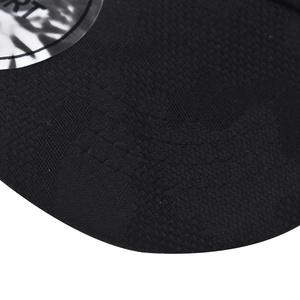 Detail of black mesh baseball cap fabric and reflective silver circular brand patch