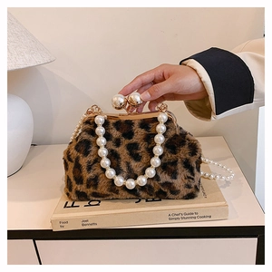 Detailed close-up of leopard print plush bag featuring elegant pearl handle and gold clasp