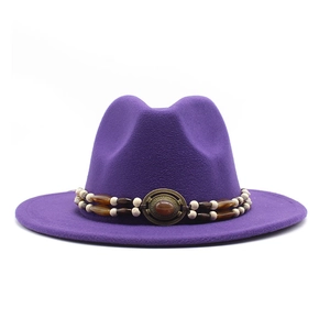 Detail of purple wool fedora hat featuring an ethnic beaded band and gemstone buckle