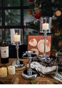 Close-up of three silver metal candle holders with glass covers and aroma candles